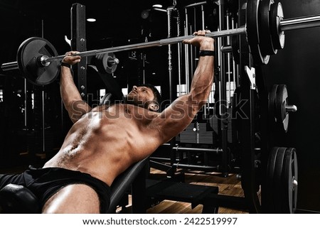 handsome young man doing bench press workout in gym, Fitness motivation, sports lifestyle, health, athletic body, body positive. Film grain, selective focus Royalty-Free Stock Photo #2422519997