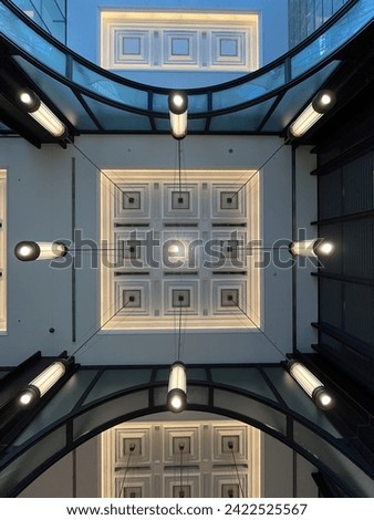 The ceiling inside the shopping mall near Tokyo Station features modern architectural design with sleek lines, decorative panels, adding visual interest and enhancing the overall ambiance of the mall.