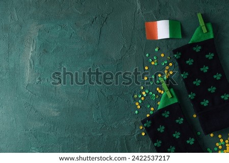 Italian flag and dark socks with clover on green background, space for text