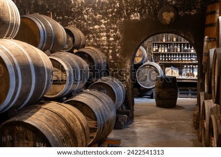 Aging process of cognac spirit in old dark French oak barrels in cellar in distillery house, Cognac white wine region, Charente, Segonzac, Grand Champagne, France Royalty-Free Stock Photo #2422541313