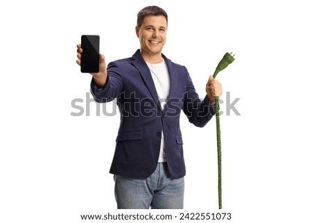 Man holding a green electric cable with a plug and a smartphone isolated on white background