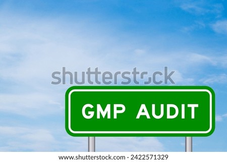 Green color transportation sign with word GMP (Good manufacturing practice) audit on blue sky with white cloud background