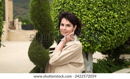 Photo of a woman 40-44 years old in a light jacket outdoors. Royalty-Free Stock Photo #2422572059