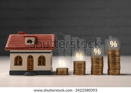 Mortgage rate. Model of house, stacked coins, graphs, percent signs and upward arrows