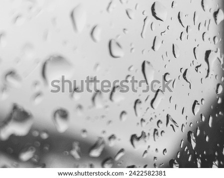 Raindrops on the window glass form intricate patterns. Each drop contains a tiny world inside, reflecting muted light and creating a mesmerizing scene of calm and introspection. 