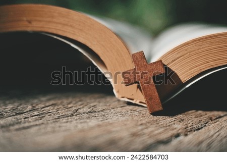 close up small cross and book on wood table, copy space for text Royalty-Free Stock Photo #2422584703