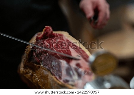 the hands of a pata negra Iberian ham cutter Royalty-Free Stock Photo #2422590957