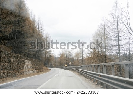 Picture of mountain road taken from car, through dirty windshield