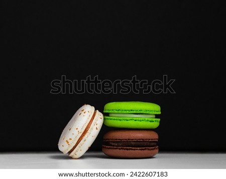 bright macaroon cookies on a black background