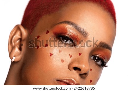 Creative makeup for Valentines day. Portrait of female fashion model isolated on white studio background. Beautiful woman with spring makeup in the shape of small hearts. Beauty concept.