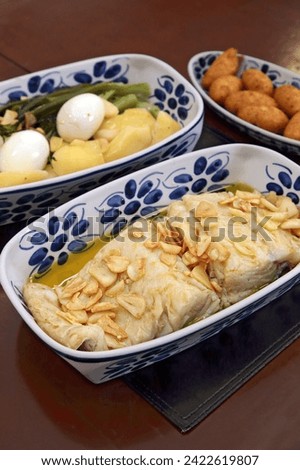 oven-baked cod with thin slices of garlic and olive oil. Served with broccoli, eggs and boiled potatoes