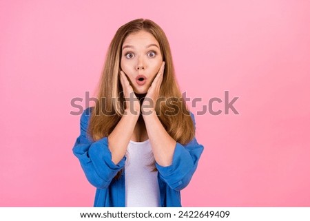 Photo of impressed shocked girl wear blue shirt arms cheeks empty space isolated pink color background