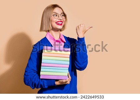 Photo of smart attractive girl hold pile stack book look direct finger empty space isolated on beige color background