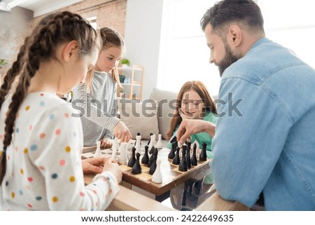 Portrait of nice intellectual focused cheerful family playing chess with alone dad free spare time at home house living-room indoors Royalty-Free Stock Photo #2422649635