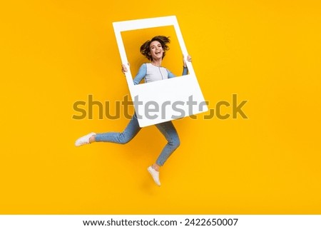 Full size porrtait of energetic nice girl hold album card jump fly empty space isolated on yellow color background