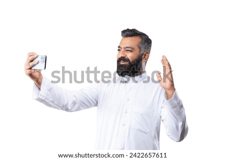 Young Arab man taking selfie or talking on a video call. Isolated on a white background