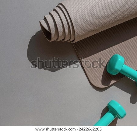 Sport or workout concept flat lay with blue dumbbells, yoga mat on the grey background. Copy space Royalty-Free Stock Photo #2422662205