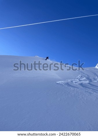 Heli-skiing and ski touring on a cloudless day with fresh powder Royalty-Free Stock Photo #2422670065