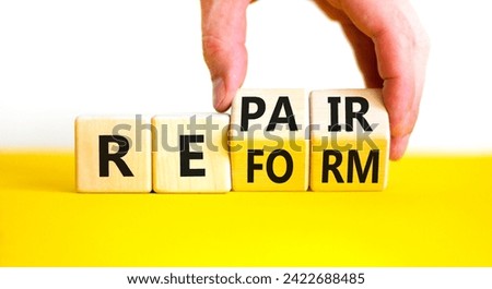 Reform and repair symbol. Concept words Reform Repair on wooden block. Beautiful yellow table white background. Businessman hand. Business reform and repair concept. Copy space.