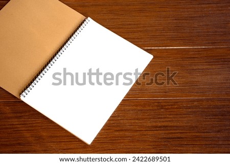 Empty open blank white notebook or blank white paper on a brown wooden plank background with a beautiful pattern.