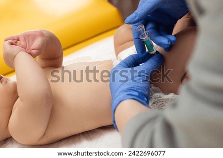 
Pediatrician administring vaccination to little baby.  Pediatrician is giving injection in leg to small baby. Close up. Children health care and disease prevention.