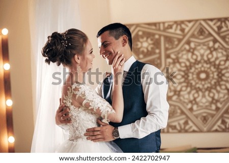 bride and groom hugging in a bright room