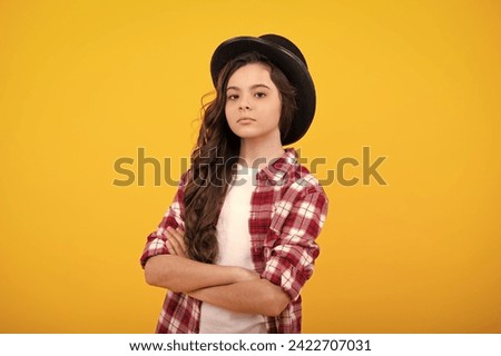 Child girl in magician hat, cylinder hat isolated on yellow background. Headwear. Clothes accessories. Fashion headwear for gentlemen in vintage style, old classic cylinder. Royalty-Free Stock Photo #2422707031