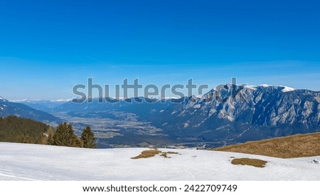 Panoramic view from snow covered alpine meadow on Dreilaendereck in untamed Karawanks, Carinthia, Austria. Alpine landscape in spring in Austrian Alps. Looking at mountain peak Dobratsch. Wanderlust