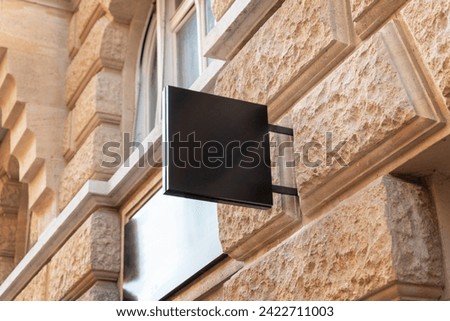 Clean black square sign in a modern city street, providing a perfect spot for logo promotion and effective branding