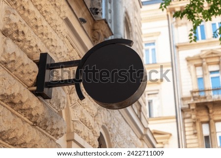 Clean black circle logo sign stands in a modern city street, offering prime space for logo promotion and effective branding