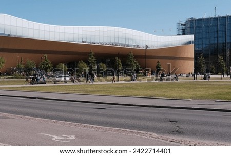 Helsinki, Finland - June 10 2023: The view on the modern building of the  Helsinki's new Central Library "Oodi" with bicycle path on the foreground