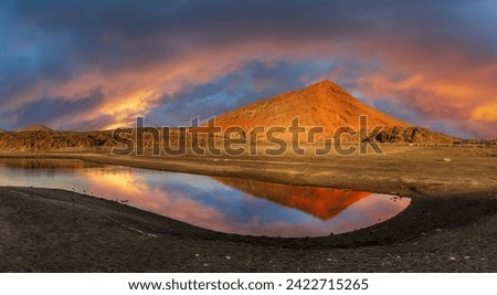 Captivating sunset at Los Hervideros, Lanzarote, reflecting on tranquil waters with the fiery glow of volcanic landscapes - ideal for stunning visuals Royalty-Free Stock Photo #2422715265