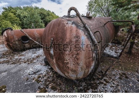 Rusty cistern in wrecking yard near Illinci village in Chernobyl Exclusion Zone, Ukraine Royalty-Free Stock Photo #2422720765