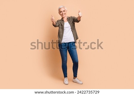 Full body photo of attractive retired woman show thumb up good quality wear trendy khaki clothes isolated on beige color background