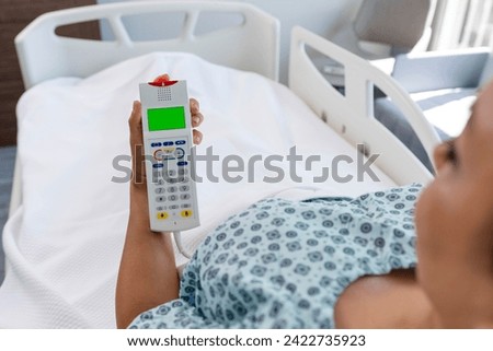 Nurse call button in patient room in modern hospital. Hand pushing nurse call button. patient press red emergency button to calling nurse for help in hospital Royalty-Free Stock Photo #2422735923