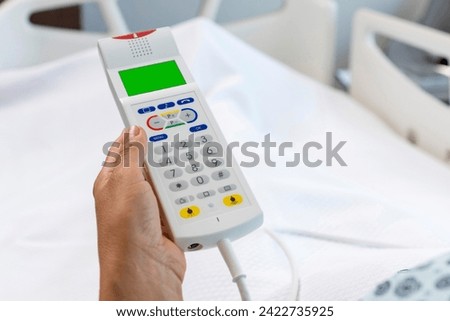 Nurse call button in patient room in modern hospital. Hand pushing nurse call button. patient press red emergency button to calling nurse for help in hospital Royalty-Free Stock Photo #2422735925