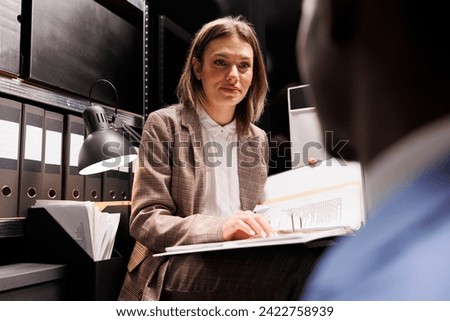 Managers organizing at business files, analyzing bureaucracy record in storage room. Diverse businesspeople discussing accountancy report, checking administrative documents in corporate depository Royalty-Free Stock Photo #2422758939