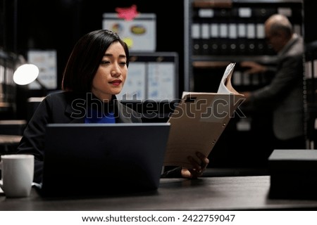 Administrative businesswoman checking bookkeeping analytical data paperwork. Accountant employee in business company file cabinet depository filled with flowcharts and folders Royalty-Free Stock Photo #2422759047