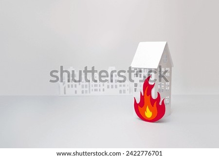 Paper house and flame made of cardboard on gray background.  Property insurance concept. Selective focus, copy space