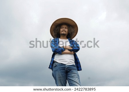 Asian farmer looking far ahead with a cap in cloudy weather. clo