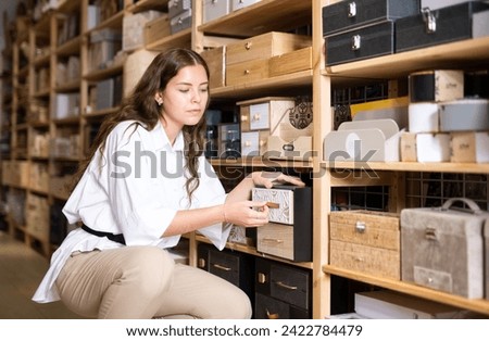 Woman choice wooden box in decoration and furniture store