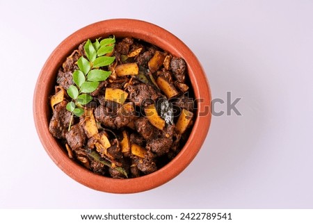 Spicy red beef fry curry and brown rice South Indian dish Kerala, India. side of Ghee rice, Appam, Parotta, Puttu. traditional Christian Muslim feast dish. Buffalo roast, meat pepper fry with coconut. Royalty-Free Stock Photo #2422789541