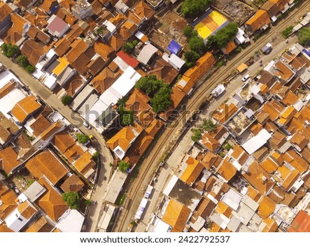 Amazing landscape of Train Tracks. Bird's eye view from drone of a railway line in the middle of densely populated houses in Cicalengka, Indonesia. Shot from a drone flying 200 meters high.