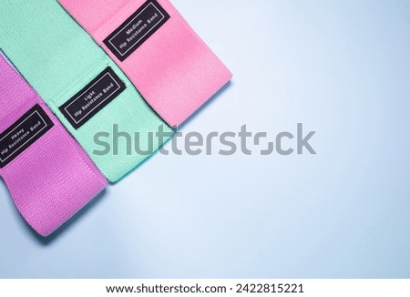 Fitness elastic band. Sport and healthy active lifestyle concept. A set of colorful elastic fitness band on blue background. 