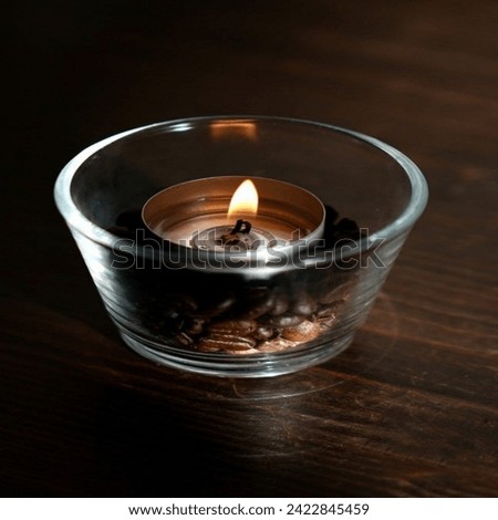 A dark picture of candle in a cup.