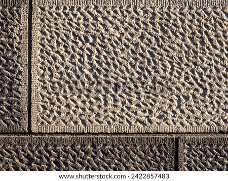 Wall with decorative imitation of stone blocks. Rough surface, painted in brown color. Vintage texture is perfect for background and design. Closeup.