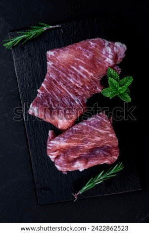 Raw iberian pork meat on black slate secreto ibérico Royalty-Free Stock Photo #2422862523