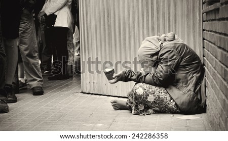 homeless girl is begging for money Royalty-Free Stock Photo #242286358