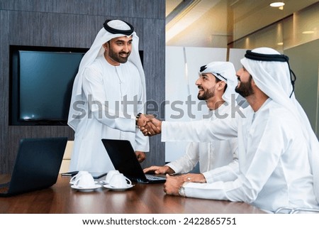 Group of corporate arab businessmen meeting in the office - Middle-eastern businesspeople wearing emirati kandora working in a meeting room, Dubai Royalty-Free Stock Photo #2422865751