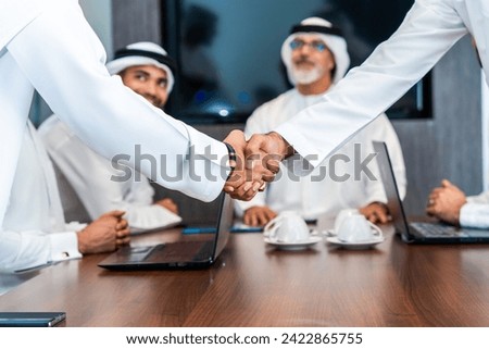Group of corporate arab businessmen meeting in the office - Middle-eastern businesspeople wearing emirati kandora working in a meeting room, Dubai Royalty-Free Stock Photo #2422865755